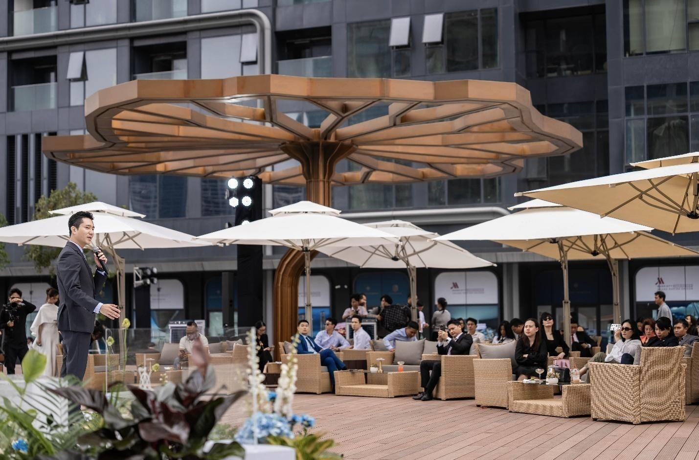 A group of people sitting outside with umbrellasAI-generated content may be incorrect.